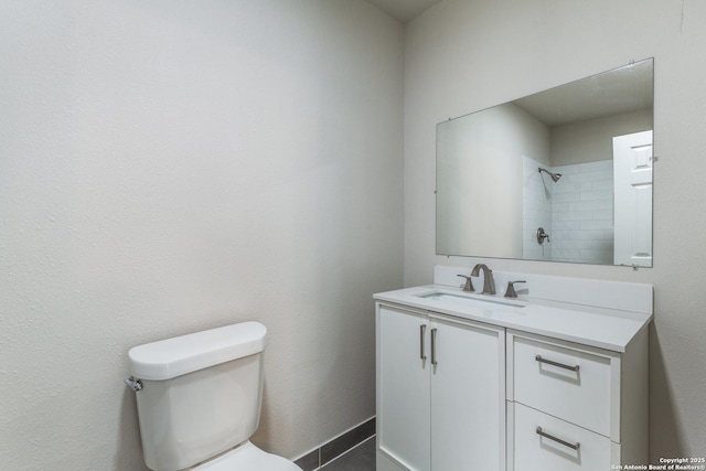 full bath featuring toilet, baseboards, walk in shower, and vanity