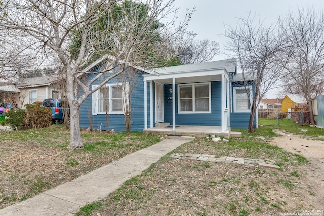 bungalow-style house with covered porch and fence