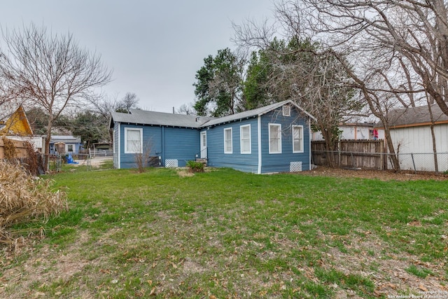 rear view of property with fence private yard and a lawn