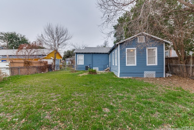 back of property featuring a fenced backyard and a lawn