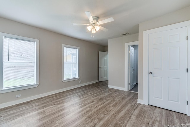 unfurnished bedroom with visible vents, ceiling fan, light wood-style flooring, and baseboards