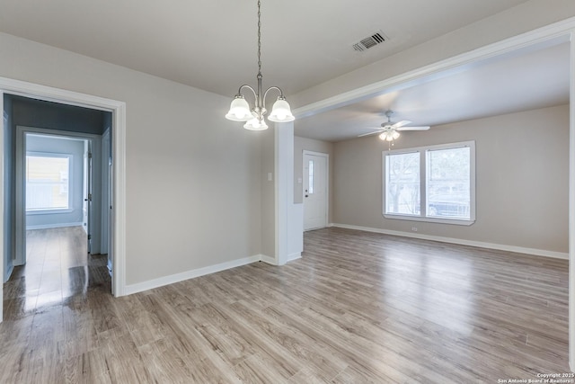 empty room featuring baseboards, light wood-style floors, visible vents, and a healthy amount of sunlight