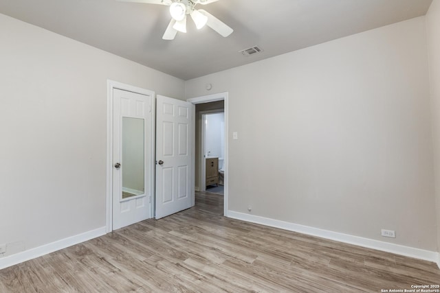 unfurnished room with light wood-style floors, baseboards, visible vents, and ceiling fan