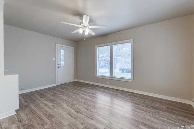 empty room featuring light wood-style flooring, baseboards, and ceiling fan