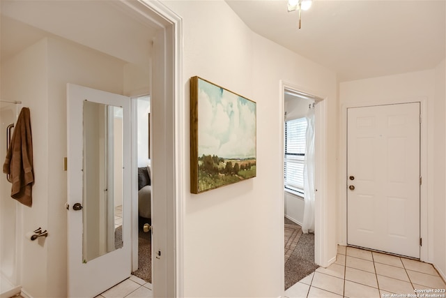 foyer featuring light tile patterned floors and light carpet