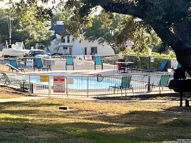 pool featuring a lawn and fence