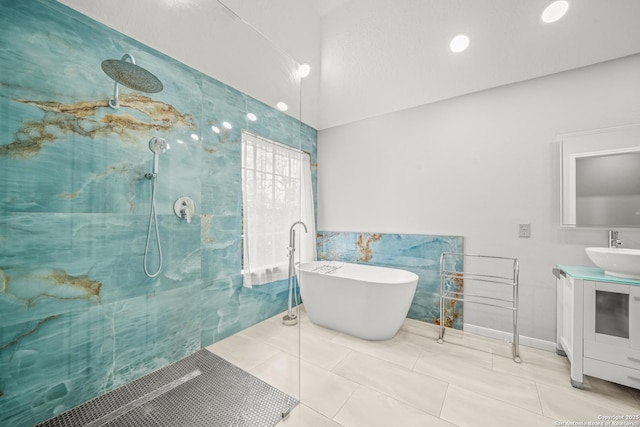 bathroom featuring a walk in shower, a freestanding tub, vanity, tile walls, and tile patterned floors