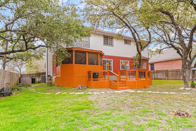 back of house with a deck, a fenced backyard, central air condition unit, a sunroom, and a yard