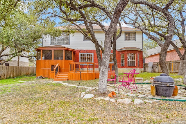 back of house with an outdoor fire pit, a sunroom, a fenced backyard, and brick siding