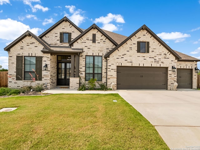 view of front of home featuring a garage, a front yard, brick siding, and driveway