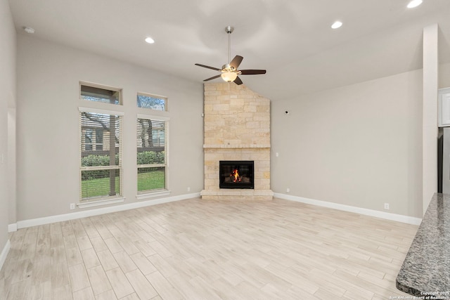 unfurnished living room featuring ceiling fan, light wood-type flooring, a fireplace, and baseboards