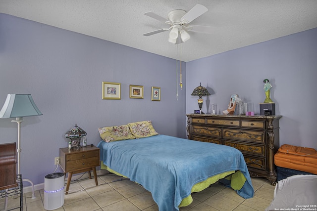 bedroom with a ceiling fan, light tile patterned flooring, and a textured ceiling