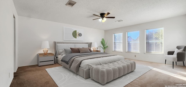 bedroom featuring a ceiling fan, light carpet, visible vents, and a textured ceiling