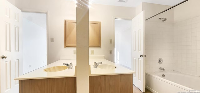 full bathroom with double vanity, washtub / shower combination, and a sink