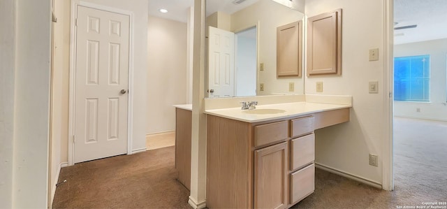 bathroom featuring baseboards, carpet flooring, and vanity