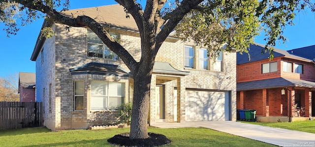 view of front of property with a garage, concrete driveway, fence, a front yard, and brick siding