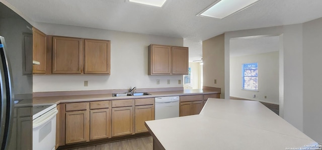 kitchen with white appliances, light countertops, and a sink