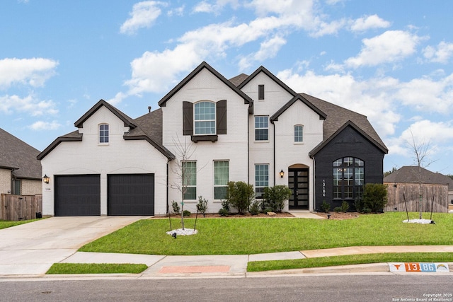 french country home featuring brick siding, concrete driveway, fence, a garage, and a front lawn