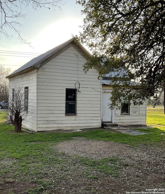 back of house with entry steps and a lawn