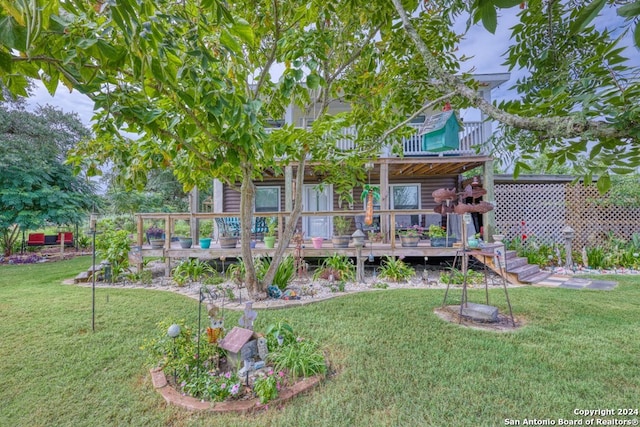 rear view of house featuring a yard and a wooden deck