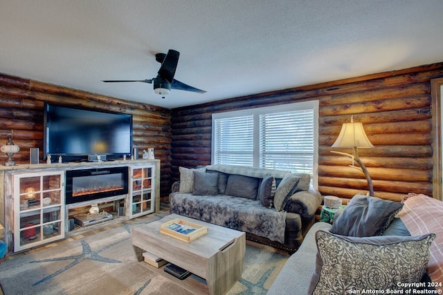 living room with rustic walls, a ceiling fan, a textured ceiling, and wood finished floors