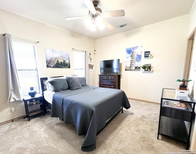 bedroom with ceiling fan, visible vents, crown molding, and light colored carpet