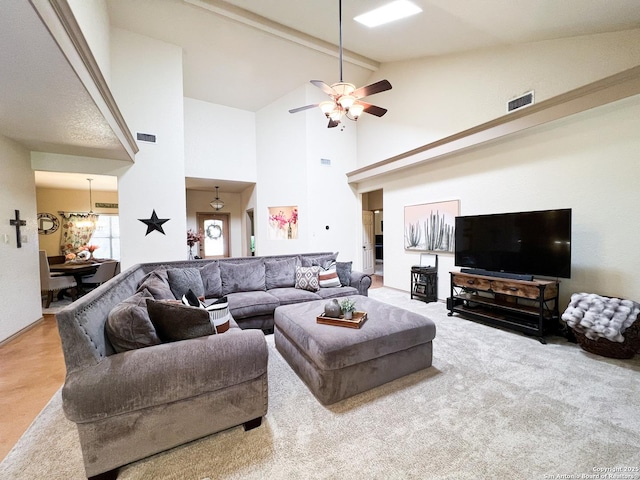 living area with high vaulted ceiling, carpet, visible vents, and ceiling fan