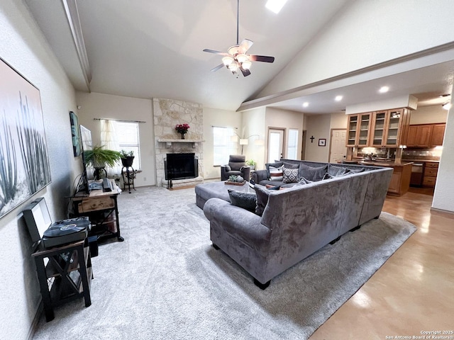 living room with high vaulted ceiling, recessed lighting, ceiling fan, and a stone fireplace