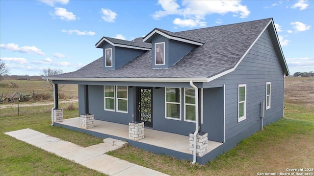 view of front of home featuring a porch, a front lawn, and a shingled roof