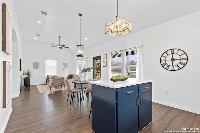 kitchen featuring a breakfast bar, a center island, light countertops, visible vents, and blue cabinets