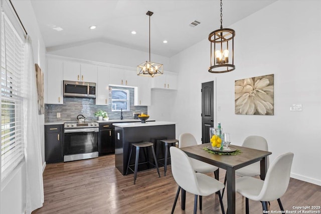 kitchen with light countertops, appliances with stainless steel finishes, a kitchen island, and white cabinetry