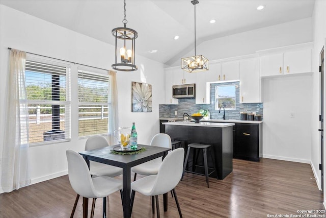 dining space with vaulted ceiling, dark wood-type flooring, and baseboards