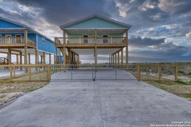 view of front of house featuring concrete driveway, stairway, a gate, fence, and a carport