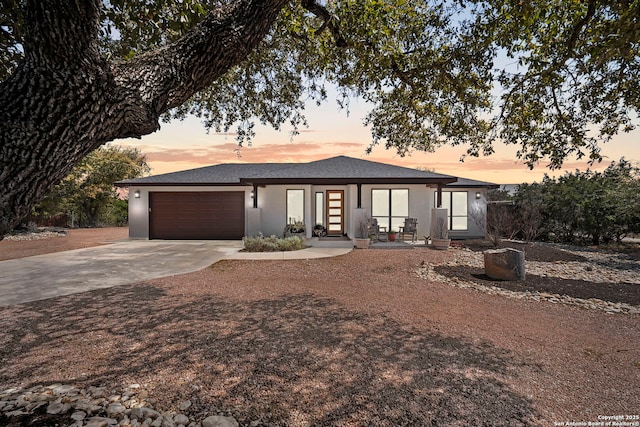 view of front facade featuring stucco siding, a garage, and concrete driveway