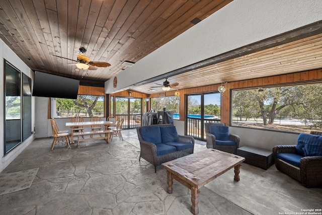 sunroom with a ceiling fan, wooden ceiling, and a healthy amount of sunlight