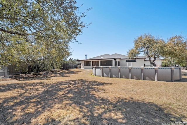 back of house with an outdoor pool and a fenced backyard