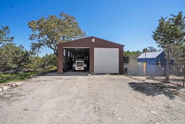 detached garage featuring fence