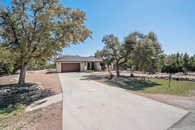 view of front of home with a garage, concrete driveway, and stucco siding