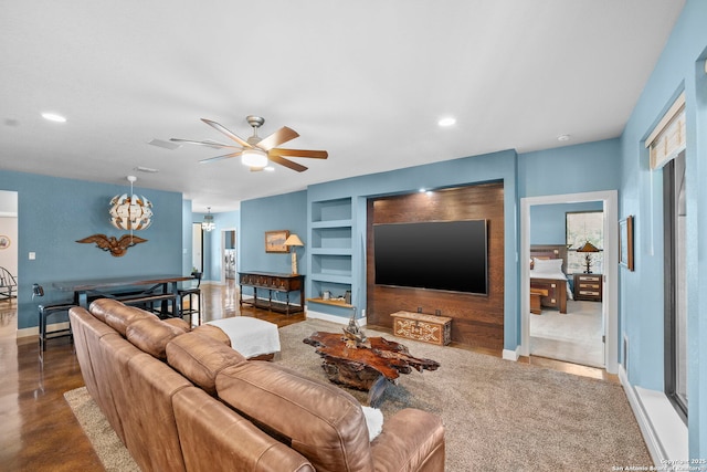 living area with built in features, baseboards, recessed lighting, and ceiling fan with notable chandelier