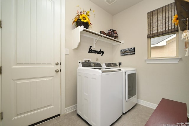 clothes washing area with washing machine and clothes dryer, light tile patterned floors, visible vents, laundry area, and baseboards