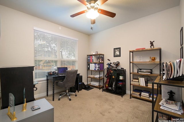 office space with light carpet, baseboards, and a ceiling fan