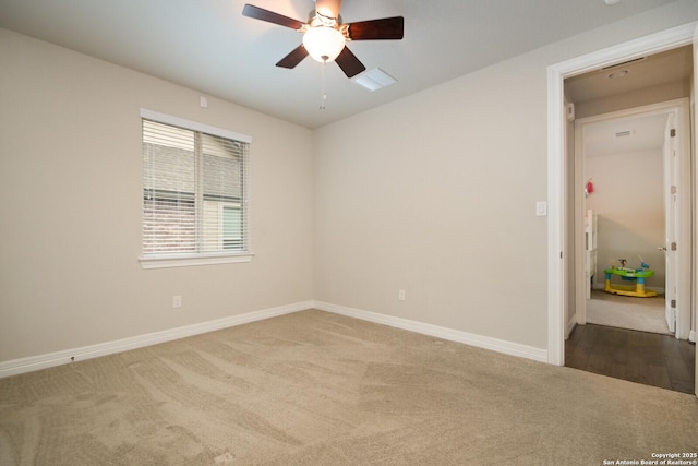 carpeted spare room with a ceiling fan and baseboards