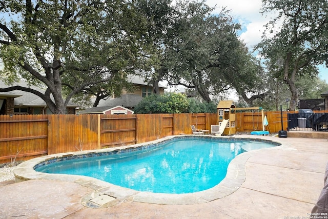 view of pool featuring a patio, a playground, a fenced backyard, and a fenced in pool