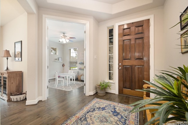 foyer with dark wood-style flooring, ceiling fan, and baseboards