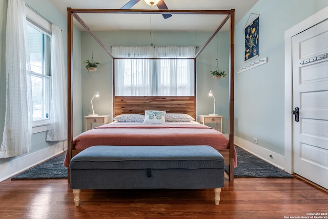 bedroom with dark wood-style floors, ceiling fan, and baseboards