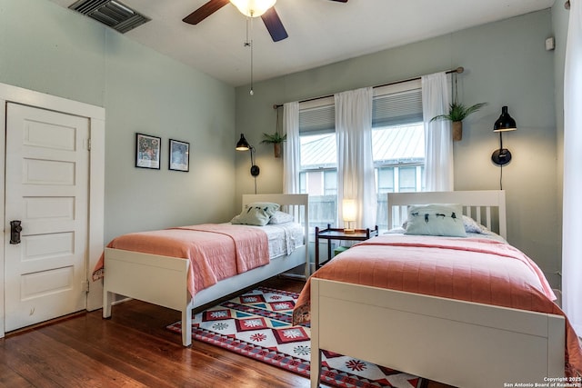 bedroom featuring visible vents, dark wood finished floors, and a ceiling fan