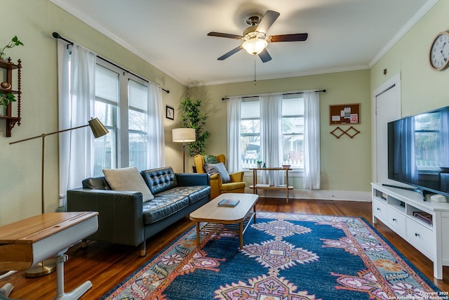 living area featuring ornamental molding, dark wood-type flooring, a ceiling fan, and baseboards