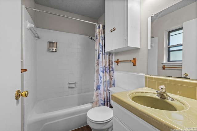 full bathroom with a textured ceiling, shower / bath combo, vanity, and toilet