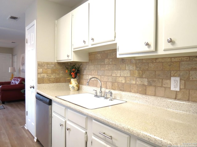 kitchen featuring a sink, visible vents, white cabinetry, light countertops, and stainless steel dishwasher