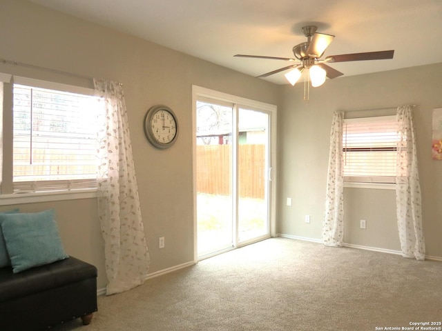 living area with carpet floors, a ceiling fan, and baseboards